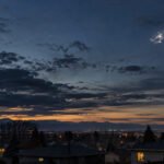 Silver unidentified object in the evening sky over Lakewood, Colorado`